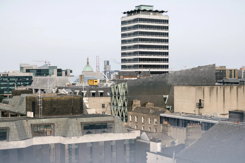 Dublin roofscape including Liberty Hall and the Irish Life building in the foreground, with the Poolbeg towers in the distance.